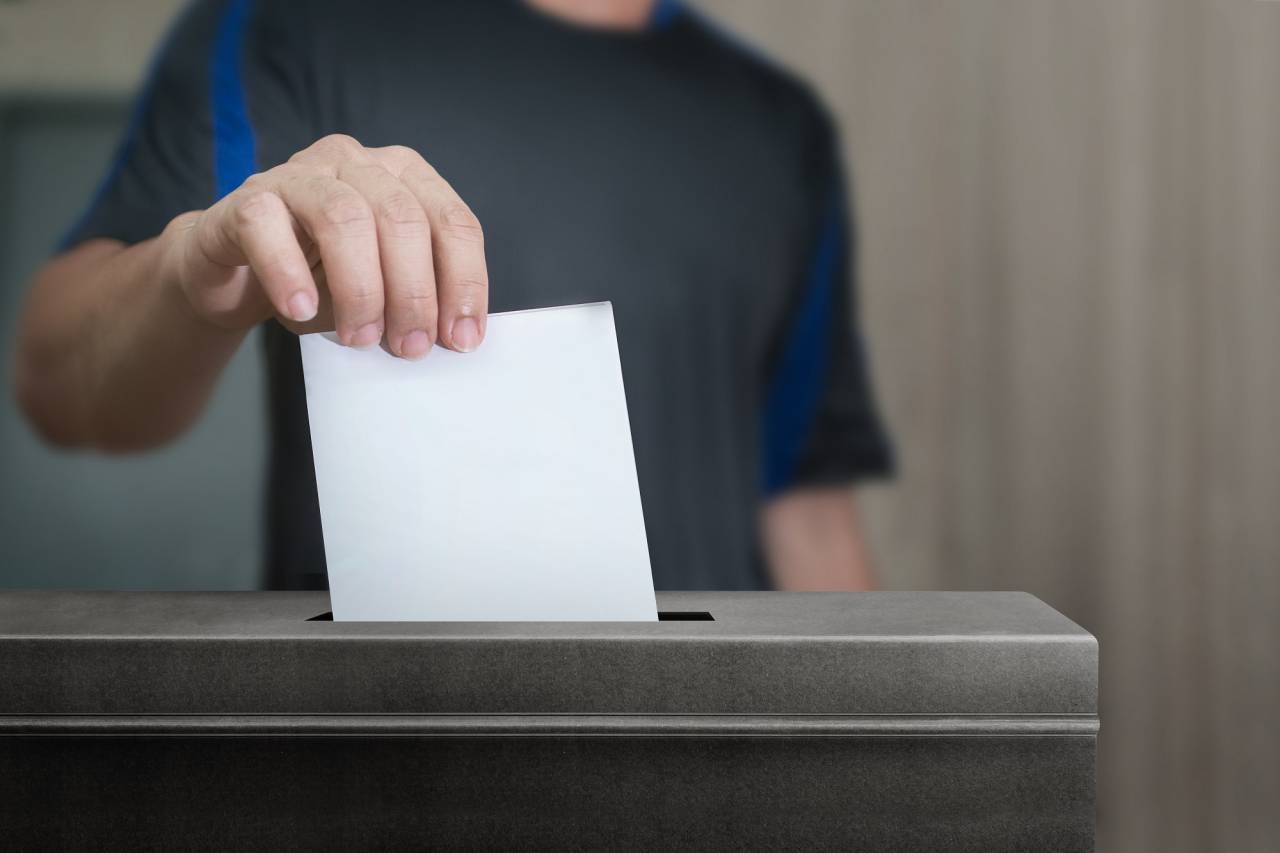 Resident inserting his vote into a ballot box