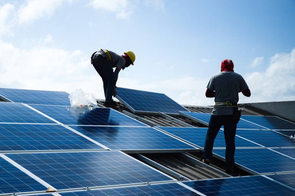 Engineers installing solar panels on a roof