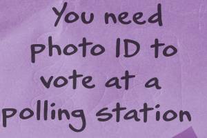 A post-it note that reads, "You need photo ID to vote at a polling station"
