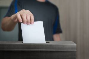 A voter placing their ballot paper in a ballot box