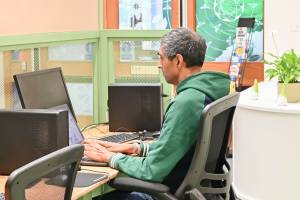 A man working at the new digital skills space in the Green Community Hub